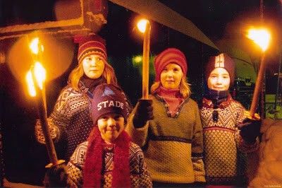 Fotografi av fire barn som holder fakler.